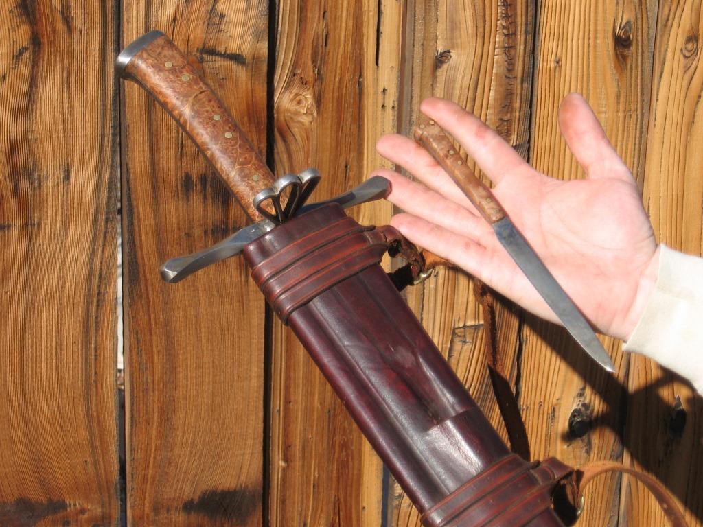 A detail showing the by-knife and part of the wooden-cored scabbard.